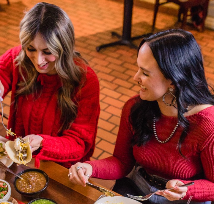 Two customers enjoying tacos at Abuelo's