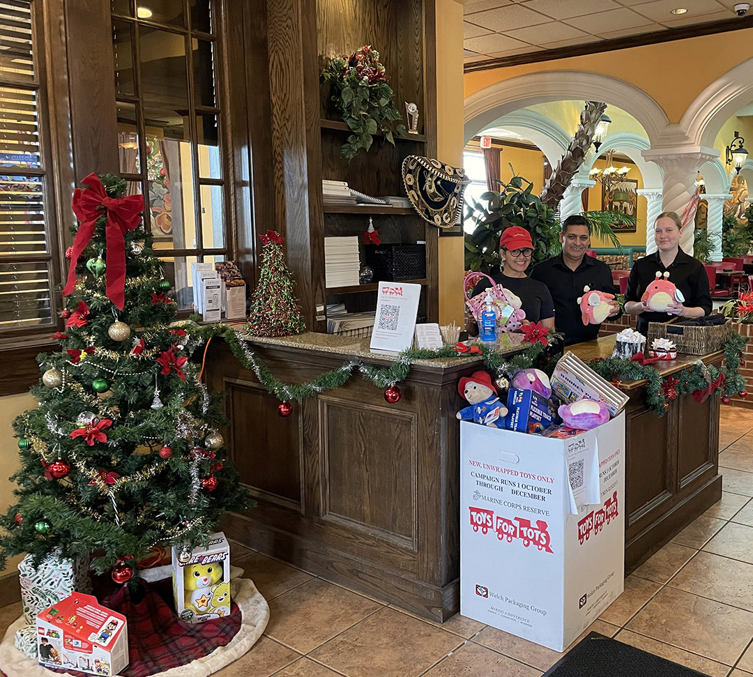 Abuelo's employees standnig by a Toys for Toys donation box